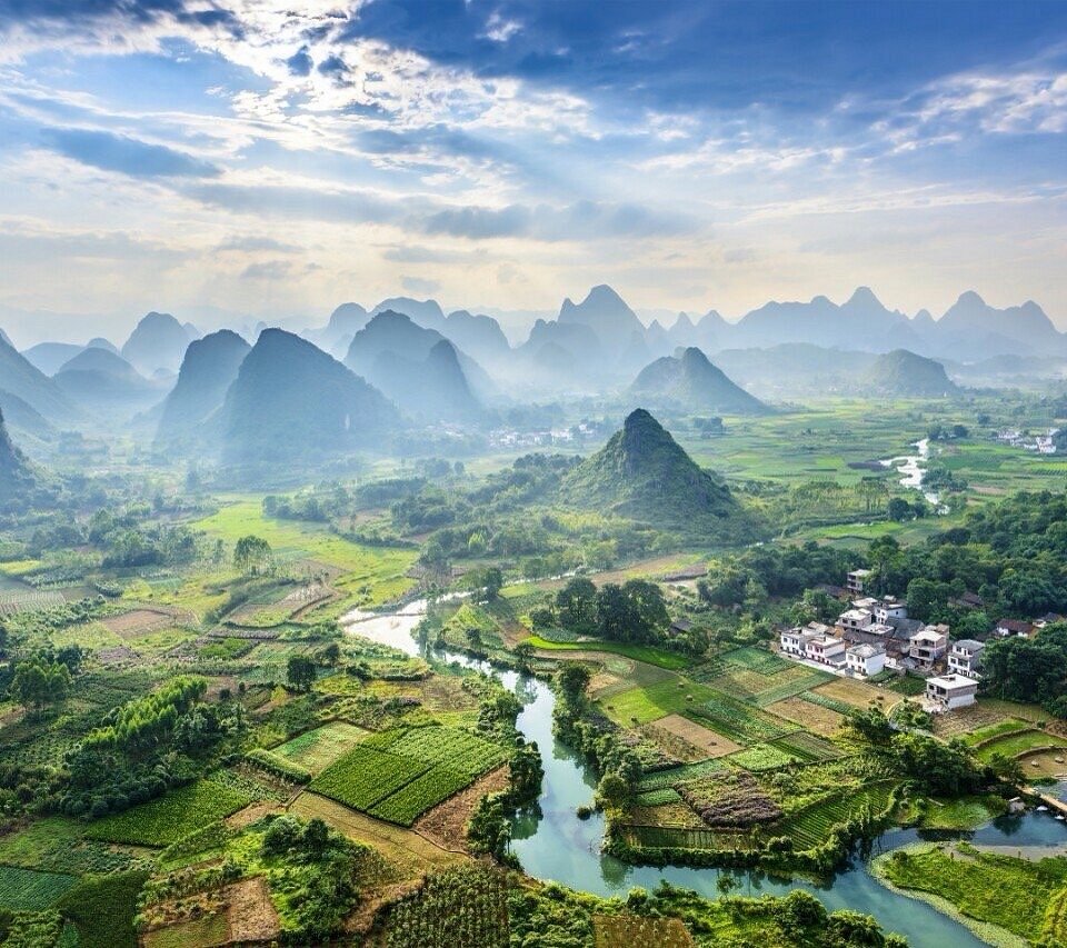 Green fields and white houses along a winding river